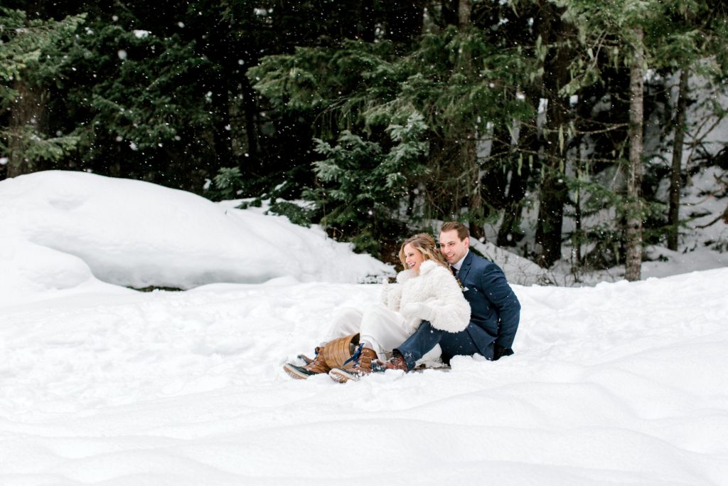 Winter wedding bride and groom sledding
