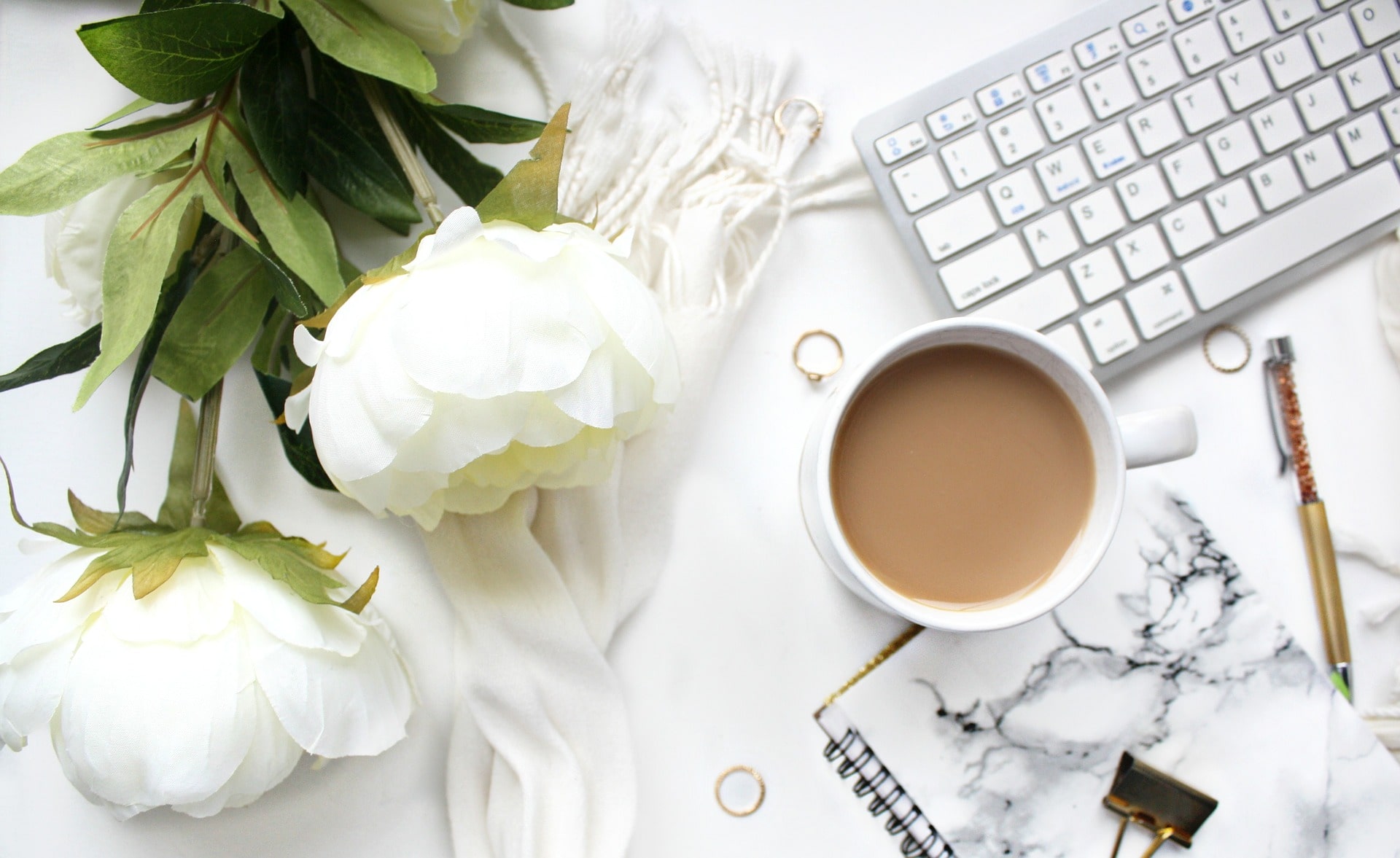 White desk with white flowers and coffee